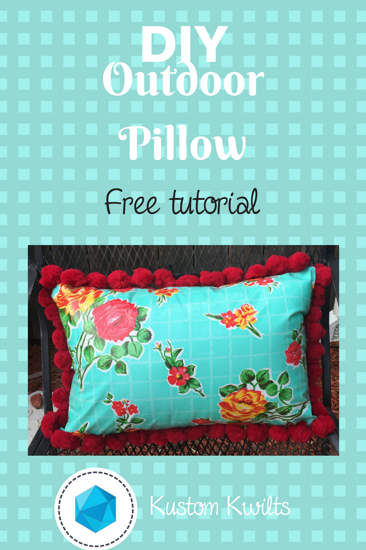 Oilcloth pillow with red pom pom trim